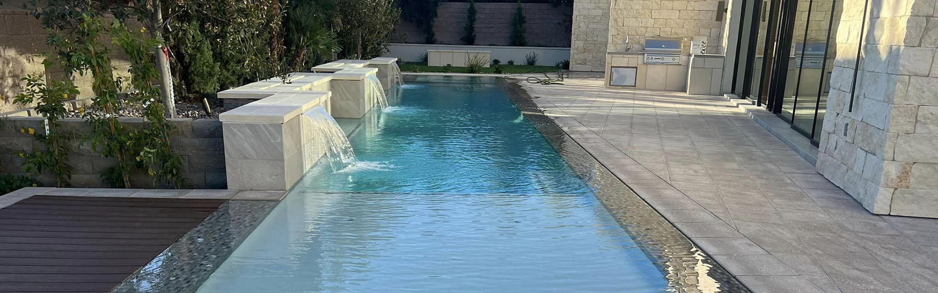Clear blue swimming pool with stone waterfall features